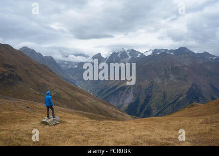 Les touristes dans les montagnes debout sur un rocher et à la recherche sur la vallée. Couvert. La crête caucasienne Principale. Zemo Svaneti, Géorgie Banque D'Images