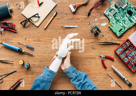 Portrait de l'homme avec l'amputé du bras prothétique sur table avec des instruments Banque D'Images