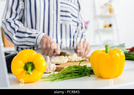 Portrait of senior woman cooking in kitchen avec les poivrons et l'oignon vert sur le premier plan Banque D'Images