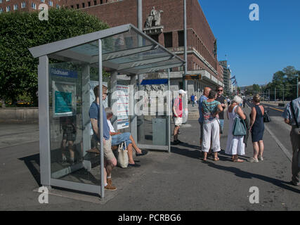 Oslo, Norvège, le 21 juillet 2018 : Les gens sont en attente d'un bus à un arrêt de bus à proximité de l'Hôtel de Ville. Banque D'Images