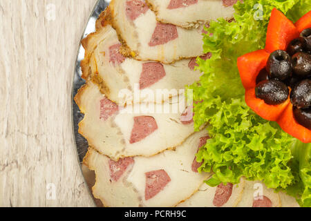 Tranches de viande sur un miroir plat à décor de verdure. Banque D'Images