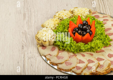 Tranches de viande sur un miroir plat à décor de verdure. Banque D'Images
