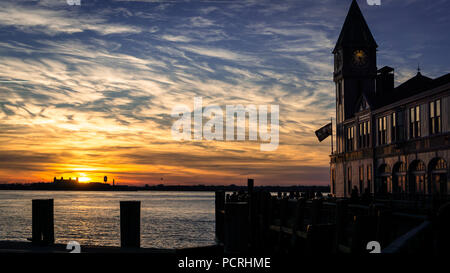 Vue sur la jetée a une belle nuit d'hiver à la légère en raison de l'hiver d'un soleil rougeoyant au coucher du soleil, de l'autre côté de la rivière, Hudon NYC, USA. Banque D'Images