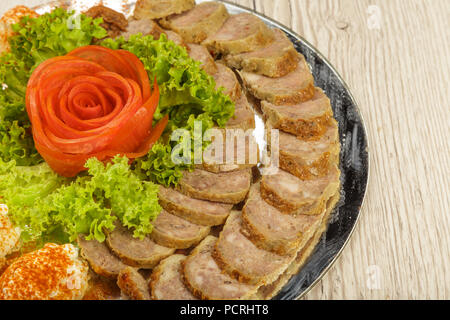Tranches de viande sur un miroir plat à décor de verdure. Banque D'Images
