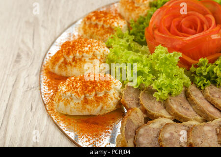 Tranches de viande sur un miroir plat à décor de verdure. Banque D'Images