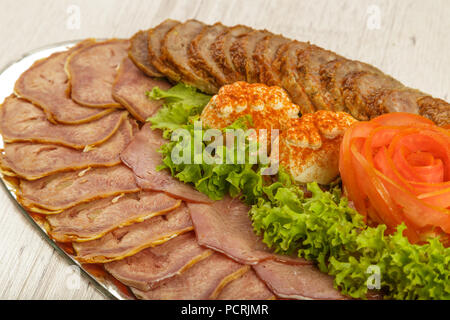 Tranches de viande sur un miroir plat à décor de verdure. Banque D'Images