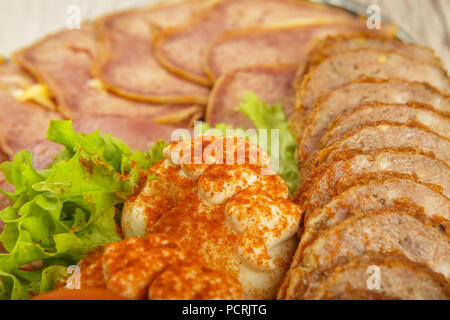 Tranches de viande sur un miroir plat à décor de verdure. Banque D'Images