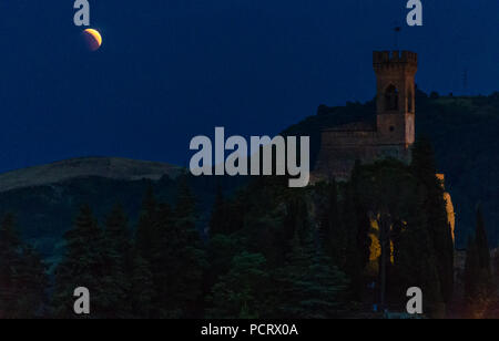 Eclipse de Lune rouge sur la tour de l'horloge en Italie Banque D'Images