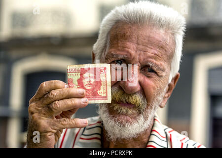 Vieux homme cubain détient un billet de 3 peso avec le portrait d'Ernesto Che Guevara dans la main, la monnaie locale, tasse, peso cubain, la pauvreté, La Habana, La Havane, La Havane, Cuba, Cuba Banque D'Images