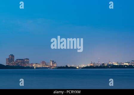 Ottawa River, Canada. À l'Est de l'Île Bate, en aval à Gatineau (Québec) sur la gauche et la colline du Parlement, Ottawa, Ontario, le droit, au crépuscule. Banque D'Images