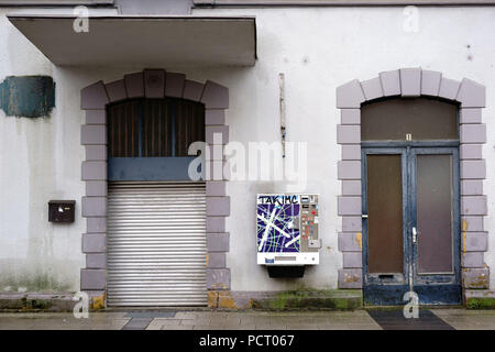 Un bâtiment vide avec abaissé les stores et d'une machine à cigarettes griffonnées sur le mur Banque D'Images