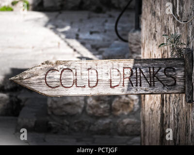 Close up photographie d'un gris brun patiné et bois boissons froides sur le côté d'un bâtiment avec l'extrémité pointue pour diriger les gens de la promenade Banque D'Images