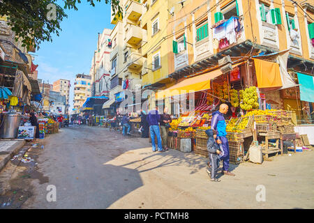 Alexandrie, Egypte - le 18 décembre 2017 : l'étroite rue du marché de Karmouz avec de nombreux étals de fruits et légumes, ses cafés et teahous Banque D'Images