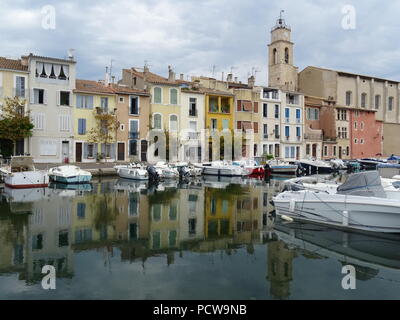 Reflet miroir du centre-ville de Martigues, France dans l'eau claire de l'ancien port sur une chaude journée d'été Banque D'Images