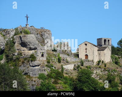 Vieille église en pierre et croix au sommet d'un éperon rocheux dans le sud de la France Banque D'Images