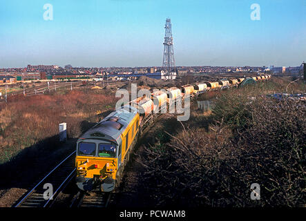 Un certain nombre de locomotives diesel de la classe 59 59104 'Village de Great Orme' avec un râteau de trémies vides Tiphook KPA stone Oak, approches entre Willesden Lane commun de haut niveau et du puits d'Acton Junction. 2e février 1995. Banque D'Images