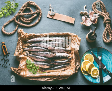 Matières sardines sur table de cuisine avec arrière-plan de citron Ingrédients ., l'ail et fines herbes pour la cuisine de fruits de mer savoureux. Préparation Cuisson des poissons Banque D'Images