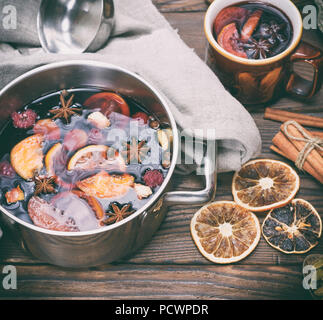 Vin chaud dans une casserole en fer sur une table en bois brun, vue du dessus Banque D'Images