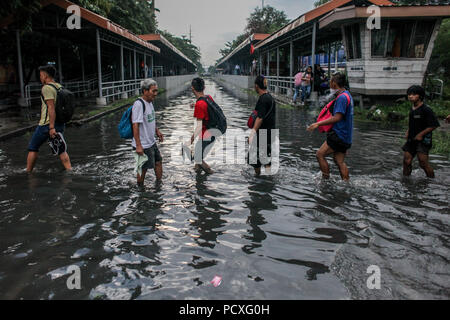 Manille, Philippines. 4 Août, 2018. Les gens traverser une voie ferrée inondée après une forte pluie à Manille, Philippines, le samedi. Le 4 août 2018. Les précipitations sont attendues dans certaines régions de Luzon et de la région métropolitaine de Manille en raison d'orages violents portés par la mousson du sud-ouest. Credit : Basilio Sepe/ZUMA/Alamy Fil Live News Banque D'Images