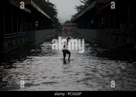 Manille, Philippines. 4 Août, 2018. Un garçon traverse une voie ferrée inondée après une forte pluie à Manille, Philippines, le samedi. Le 4 août 2018. Les précipitations sont attendues dans certaines régions de Luzon et de la région métropolitaine de Manille en raison d'orages violents portés par la mousson du sud-ouest. Credit : Basilio Sepe/ZUMA/Alamy Fil Live News Banque D'Images