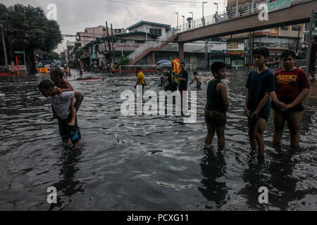 Manille, Philippines. 4 Août, 2018. Les gens patauger dans l'inondation des rues après une forte pluie à Manille, Philippines, le samedi. Le 4 août 2018. Les précipitations sont attendues dans certaines régions de Luzon et de la région métropolitaine de Manille en raison d'orages violents portés par la mousson du sud-ouest. Credit : Basilio Sepe/ZUMA/Alamy Fil Live News Banque D'Images