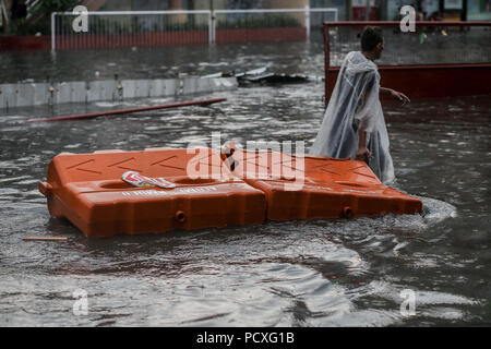Manille, Philippines. 4 Août, 2018. Un homme tire barricades de trafic qui ont été emporté par les inondations après une forte pluie à Manille, Philippines, le samedi. Le 4 août 2018. Les précipitations sont attendues dans certaines régions de Luzon et de la région métropolitaine de Manille en raison d'orages violents portés par la mousson du sud-ouest. Credit : Basilio Sepe/ZUMA/Alamy Fil Live News Banque D'Images