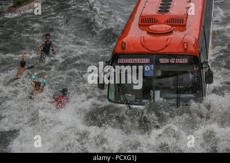 Manille, Philippines. 4 Août, 2018. Les enfants jouent en tant que véhicules Wade à travers une rue inondée pendant une forte pluie soudaine à Manille, Philippines, le samedi. Le 4 août 2018. Les précipitations sont attendues dans certaines régions de Luzon et de la région métropolitaine de Manille en raison d'orages violents portés par la mousson du sud-ouest. Credit : Basilio Sepe/ZUMA/Alamy Fil Live News Banque D'Images