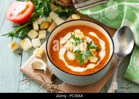 Menu de régime. Soupe de purée de tomates avec croûtons et la crème dans un bol sur une table en bois de cuisine. Le concept d'une saine alimentation. Banque D'Images