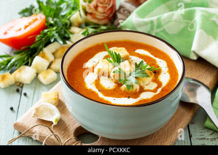 Menu de régime. Soupe de purée de tomates avec croûtons et la crème dans un bol sur une table en bois de cuisine. Le concept d'une saine alimentation. Banque D'Images