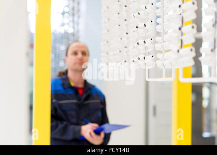 Employé d'usine Contrôle de produits sur ligne de production. Prendre des notes au cours des travailleurs le contrôle de qualité des produits Banque D'Images