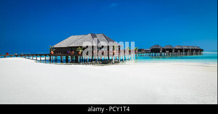 Beau complexe hôtelier tropical avec wihte beach et de l'eau turquoise pour vous détendre sur l'île Olhuveli, Maldives. Plage de sable blanc avec une barrière de corail. Best Beach Banque D'Images