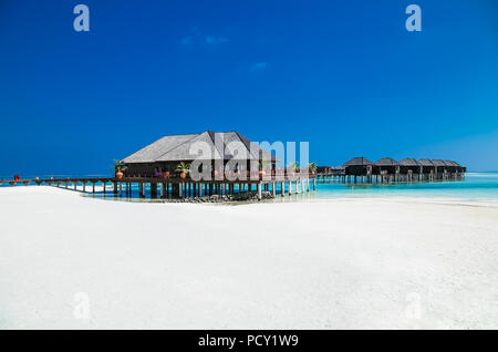 Beau complexe hôtelier tropical avec wihte beach et de l'eau turquoise pour vous détendre sur l'île Olhuveli, Maldives. Plage de sable blanc avec une barrière de corail. Best Beach Banque D'Images
