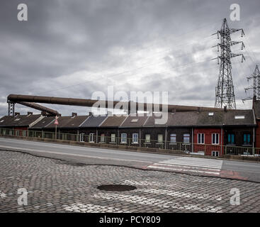 Maisons de la rue dominé par les tuyaux d'alimentation de gaz industriels dans la Rue du Chatelet, le lundi 2 avril 2018, Charleroi, Belgique Banque D'Images