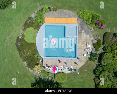 Une vue aérienne du drone de quelques amis ayant une journée de détente au bord de la piscine, un jour d'été au Chili à l'intérieur d'un joli jardin verdoyant Villa Banque D'Images