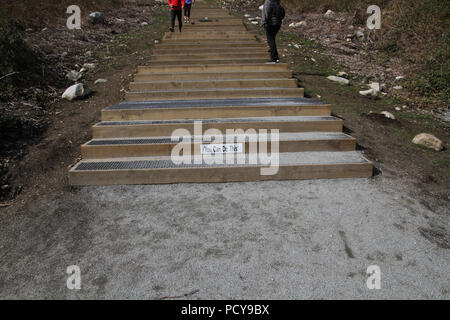 Un vous pouvez le faire en bas de l'escalier en bois avec marches métalliques menant à un sommet d'une colline avec des personnes marchant sur eux Banque D'Images