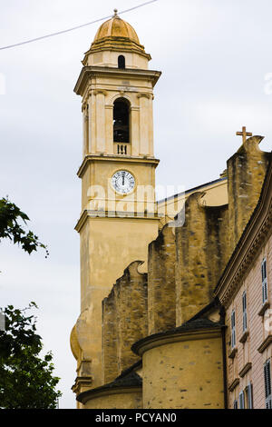 Le clocher avec horloge et le mur latéral extérieur de l'église Saint-Jean-Baptiste se dressant sous un ciel couvert à Bastia, Corse, France. Banque D'Images