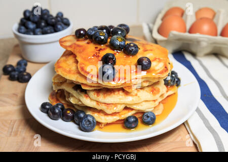 Une pile de crêpes aux bleuets de style américain, avec des bleuets et arrosé de sirop Banque D'Images