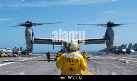 180801-N-FA806-0258 de l'OCÉAN ATLANTIQUE (Aug. 1, 2018) l'Aviation maître de Manœuvre (manutention) 1re classe Marlon Daley, de New York, dirige une MV-22 Osprey, affecté à l'Escadron d'essai et d'évaluation de l'air (HX) 21, à bord de l'envol du porte-avions USS George H. W. Bush (CVN 77). Le navire est en cours d'entraînement de routine des exercices pour maintenir l'état de préparation de l'opérateur. (U.S. Photo par marine Spécialiste de la communication de masse Roland 3e classe John) Banque D'Images