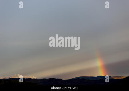 Belle et surréaliste vue d'une partie d'un arc-en-ciel sur certaines collines Banque D'Images