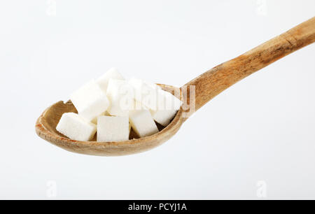 Cuillère à soupe de sucre en cubes blancs sur fond blanc Banque D'Images