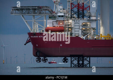 Seajacks Scylla travaillant sur la construction du parc éolien offshore Walney Extension en mer d'Irlande, Royaume-Uni. Navire de transfert d'équipage Njord Thor est vu dans la distance. Banque D'Images