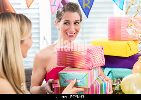 Portrait d'une femme gaie entourée par des cadeaux et des décorations de fête Banque D'Images