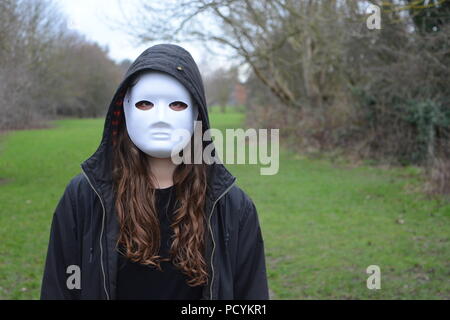 Fille dans un masque blanc et vêtu d'un sweat Banque D'Images