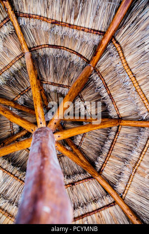 Vue de dessous d'un parapluie parasol de plage tropicale de chaume fait naturellement à partir de bois et de paille au Mexique dans les Caraïbes Banque D'Images