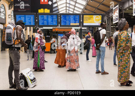 La gare de Paris Saint Lazare - femmes françaises d'origine africaine vérifiez les horaires des trains à la gare de Saint Lazare à Paris, France, Europe. Banque D'Images