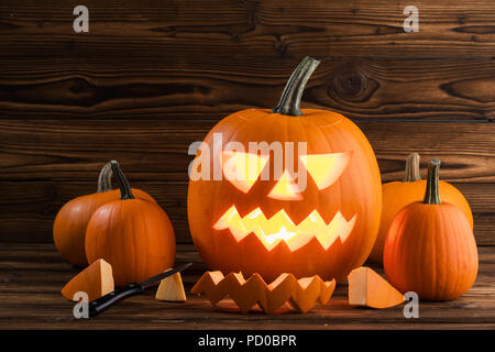 Sculpture de citrouille Halloween en cours, parties et couteau sur fond de bois Banque D'Images