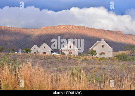 L'Afrique du Sud, une destination de voyage fantastique de faire l'expérience de troisième et premier monde ensemble. Karoo chalets dans le parc national du Karoo. Ciel d'orage. Banque D'Images