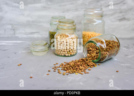 Variété de grains de haricots mungo -, les pois secs, les lentilles et les pois chiches en pots sur fond de béton gris Banque D'Images