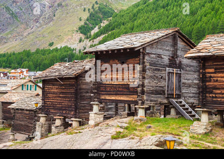 Toit en ardoise traditionnelle huttes de bois sur staddle pierres à l'entrée dans le village de Saas Fee Saastal (Vallée de Saas), canton du Valais, Suisse Banque D'Images