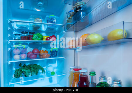 Ouvrir l'intérieur d'un réfrigérateur rempli de légumes frais, de fruits et de jus dans un régime alimentaire sain concept Banque D'Images